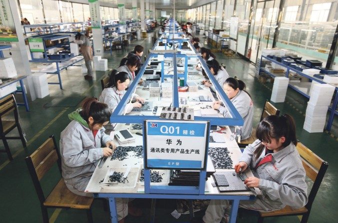 Des ouvrières trient des pièces dans une entreprise d'électronique à Tengzhou, dans la province du Shandong, à l’est de la Chine, le 1er février 2016. Alors que les revenus et les bénéfices ont augmenté, les entreprises chinoises sont en manque de liquidités. (STR / AFP / Getty Images)
